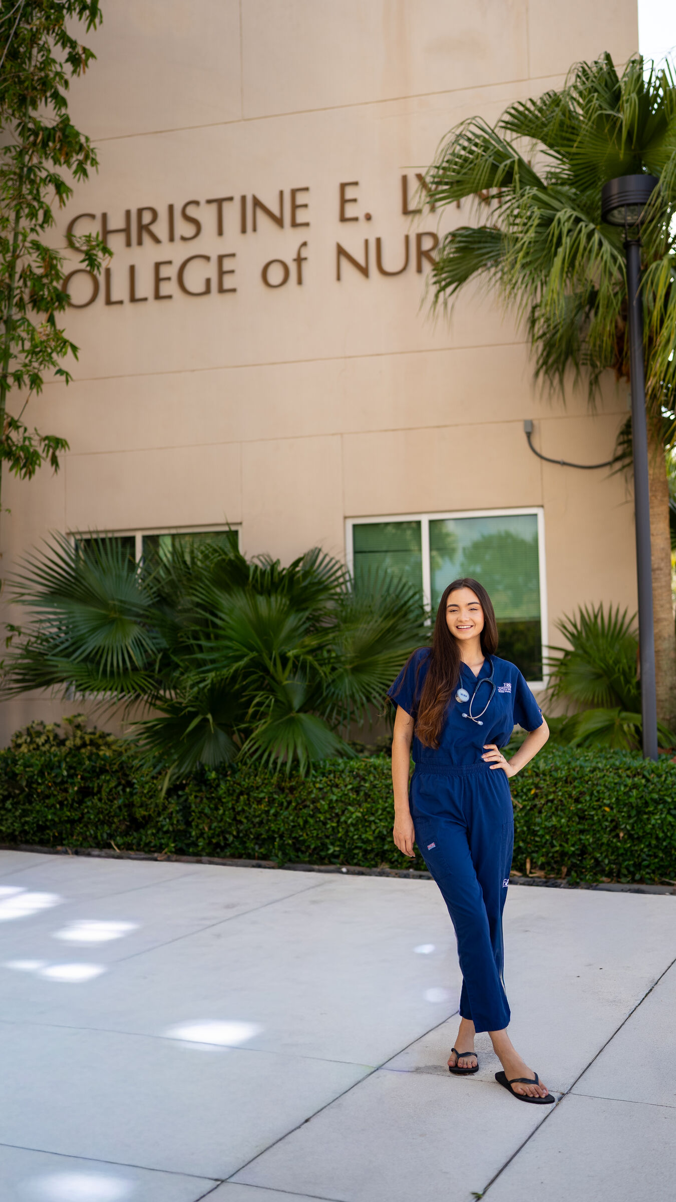 Graduate in scrubs outside her college