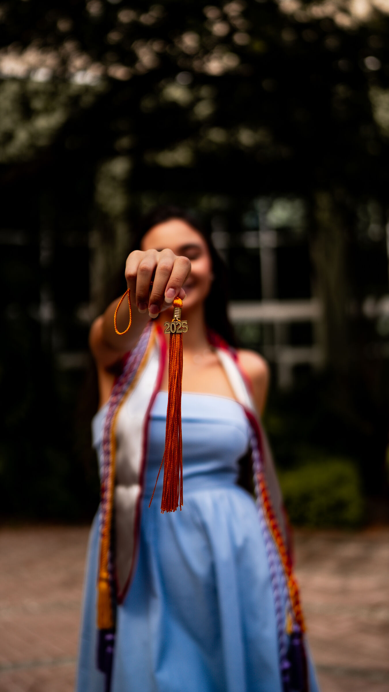 Graduate holding her tassel toward the lens