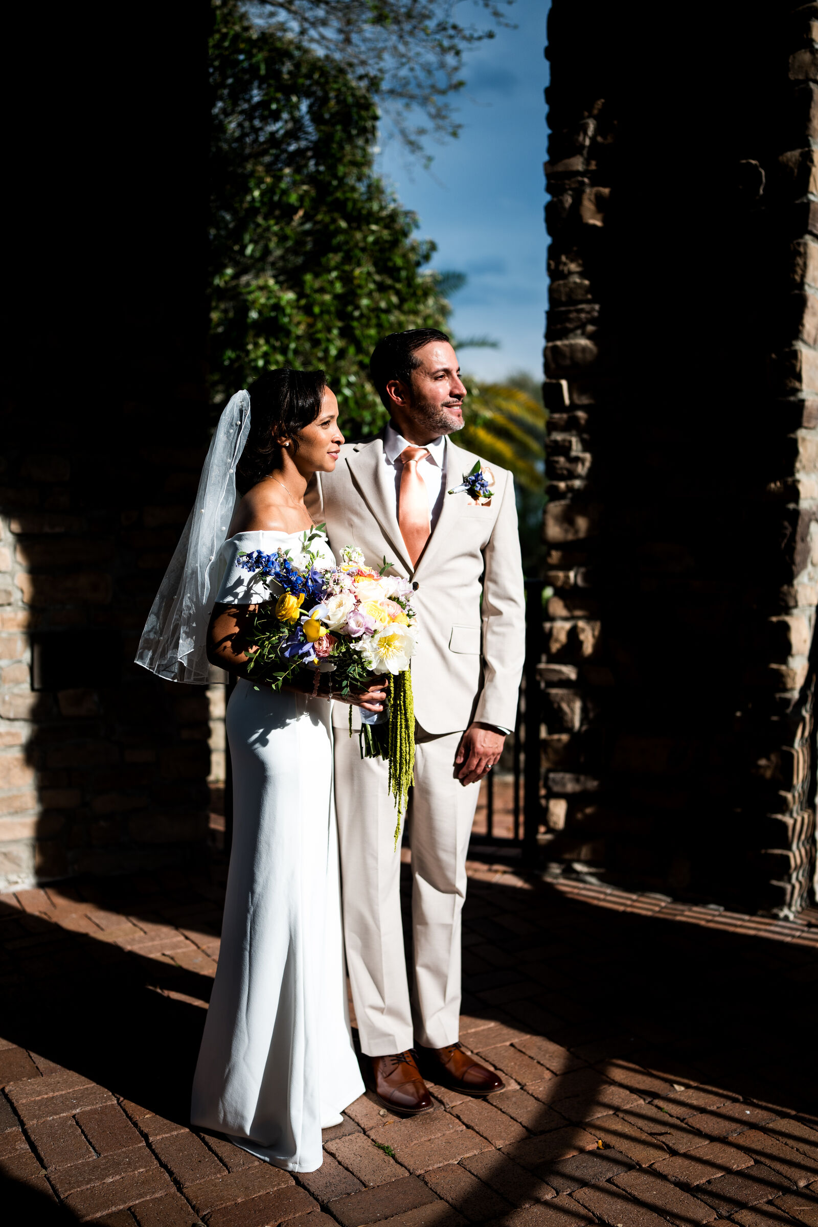 Bride and groom in late light under an archway