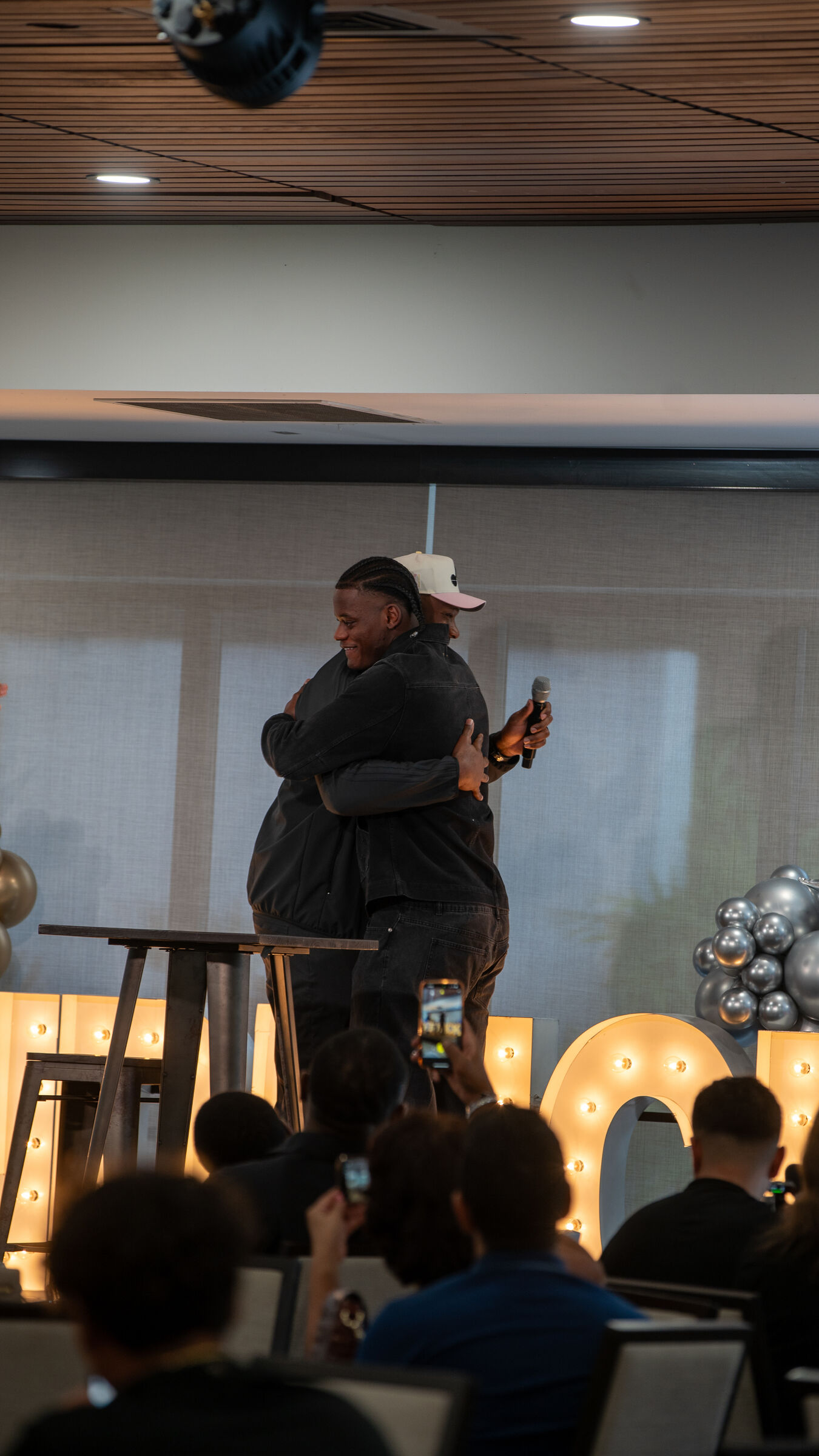 A hug on stage at an event