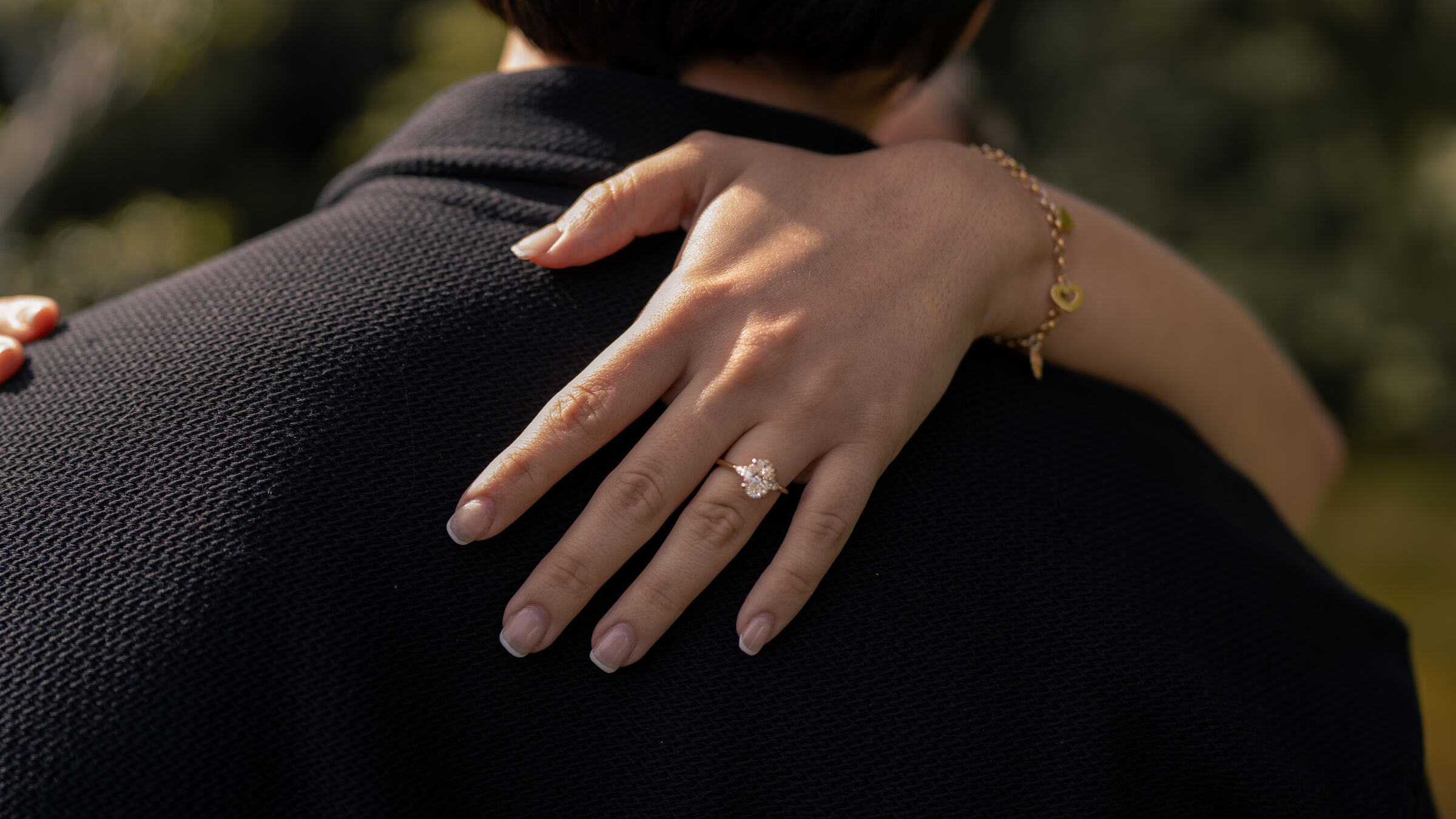 Her hand with the ring on his shoulder