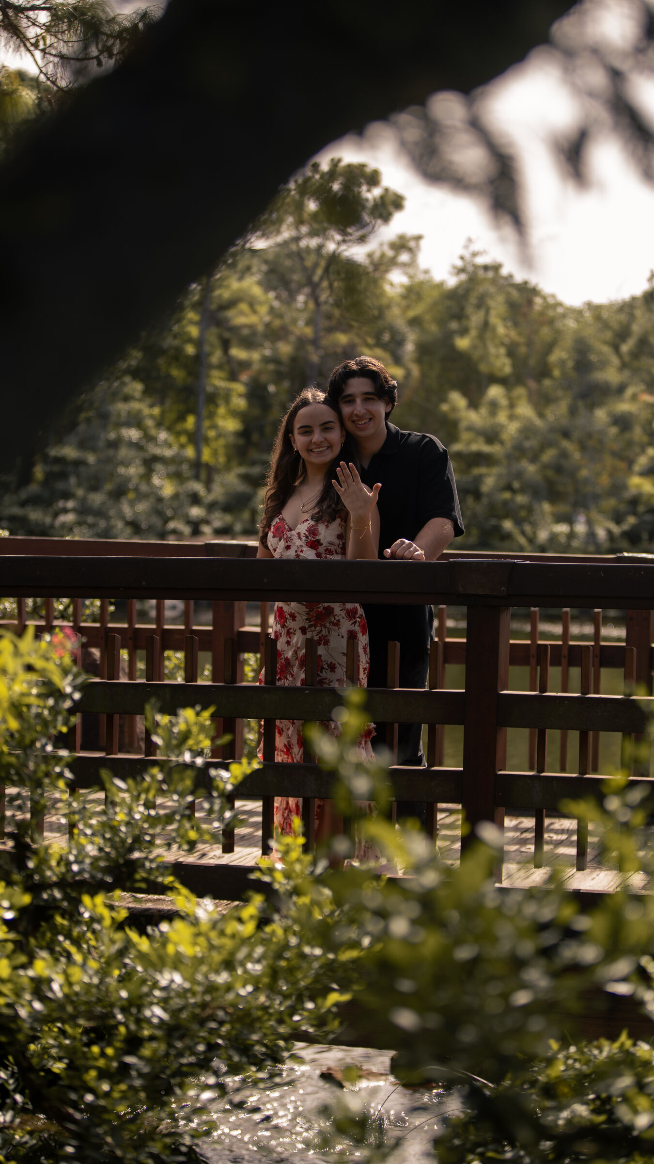 Couple on a wooden bridge framed by trees